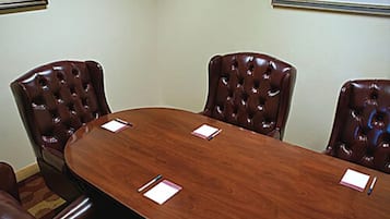 Una sala de conferencias con una mesa de madera y sillas de cuero.