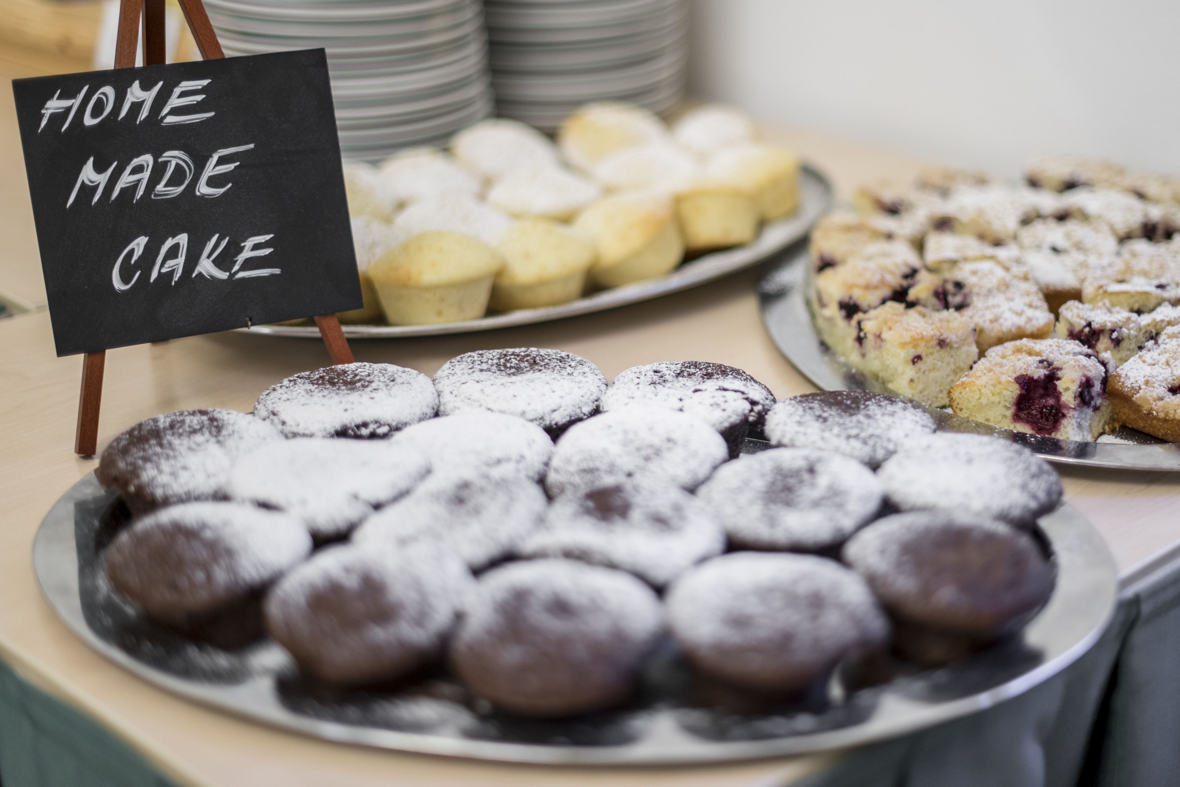 A display of various desserts with a sign reading "HOME MADE CAKE".
