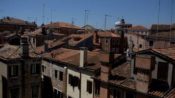 Uma área urbana densamente povoada, com telhados vermelhos tradicionais e diversas antenas nos edifícios.