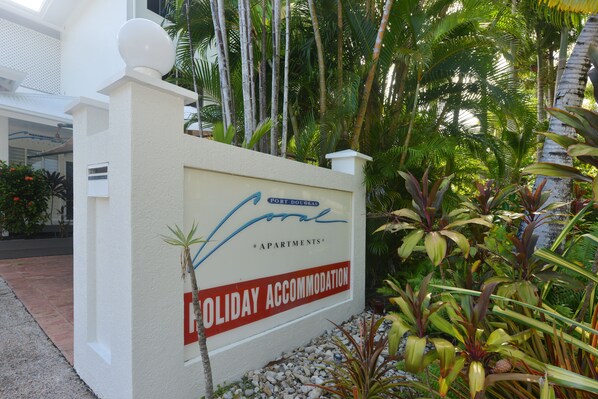 Señal de Port Douglas Apartments con etiqueta de alojamiento vacacional.