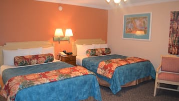 A hotel room with two beds, a chair, a nightstand, and a ceiling fan.