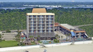 Un hotel de varios pisos con piscina y vistas a la playa.