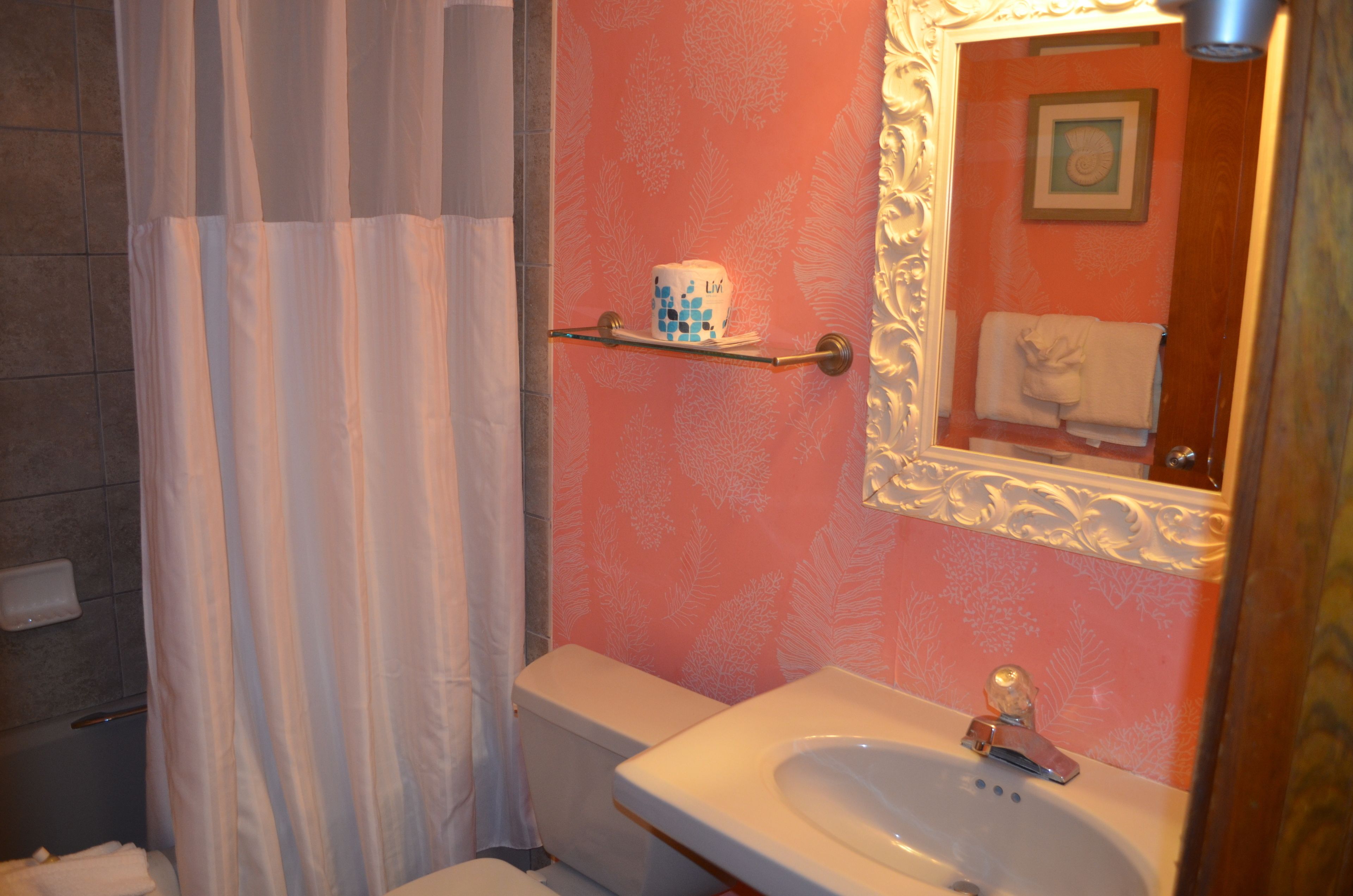 Un baño con inodoro, lavamanos y espejo.