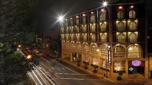 Un hotel de varios pisos con ventanas arqueadas y una fachada bien iluminada.