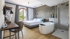 Una habitación de hotel moderna con cama, escritorio, una silla, bañera y zona de ducha.