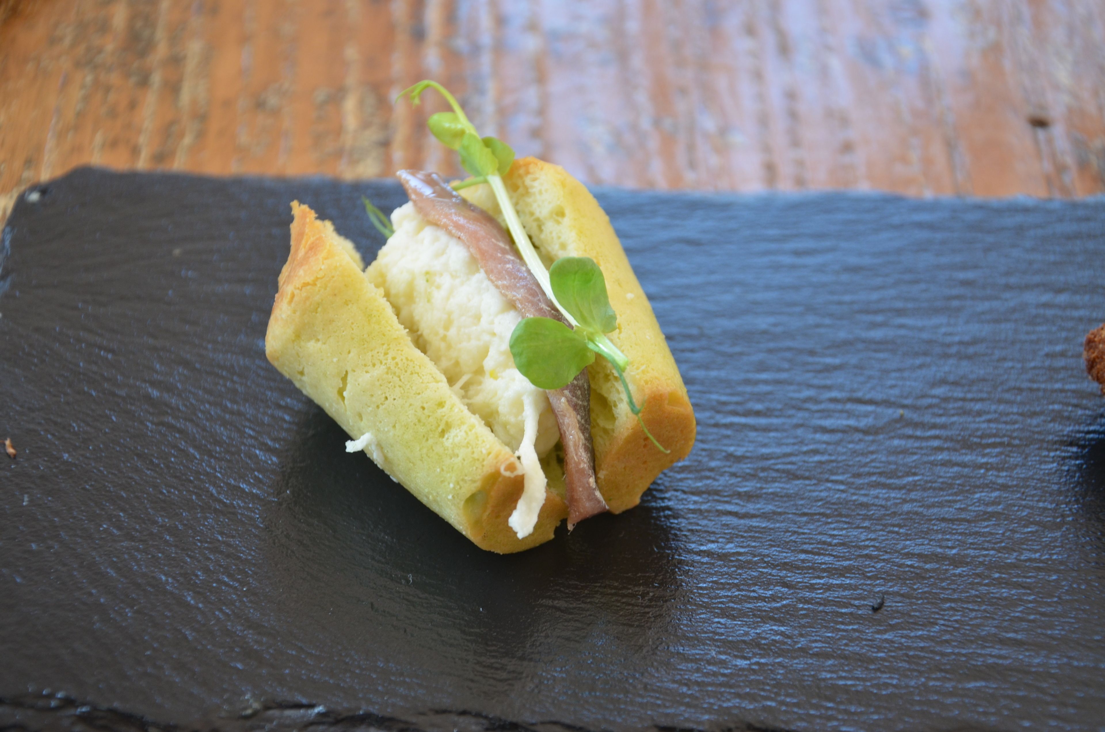 Un sandwich servi sur une assiette en ardoise.
