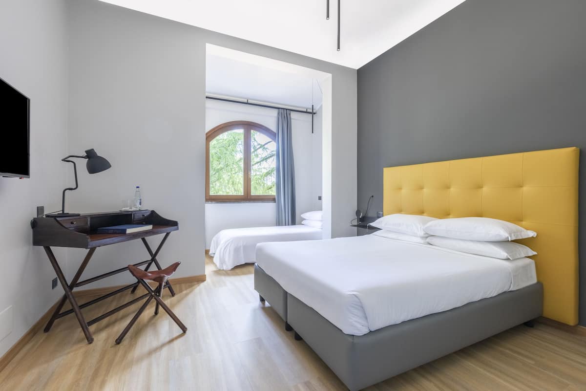 Un dormitorio moderno con una cama grande, un escritorio y una silla.