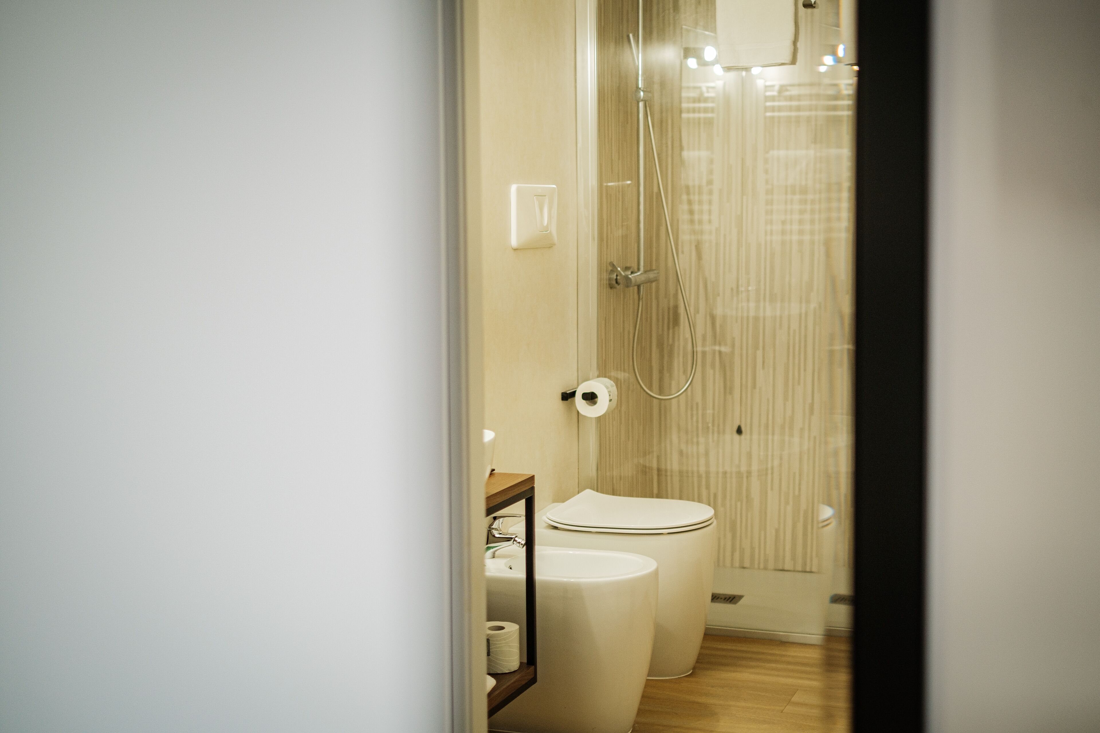 A modern bathroom with a shower, toilet, and sink.