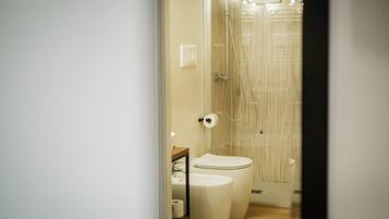 A modern bathroom with a shower, toilet, and sink.