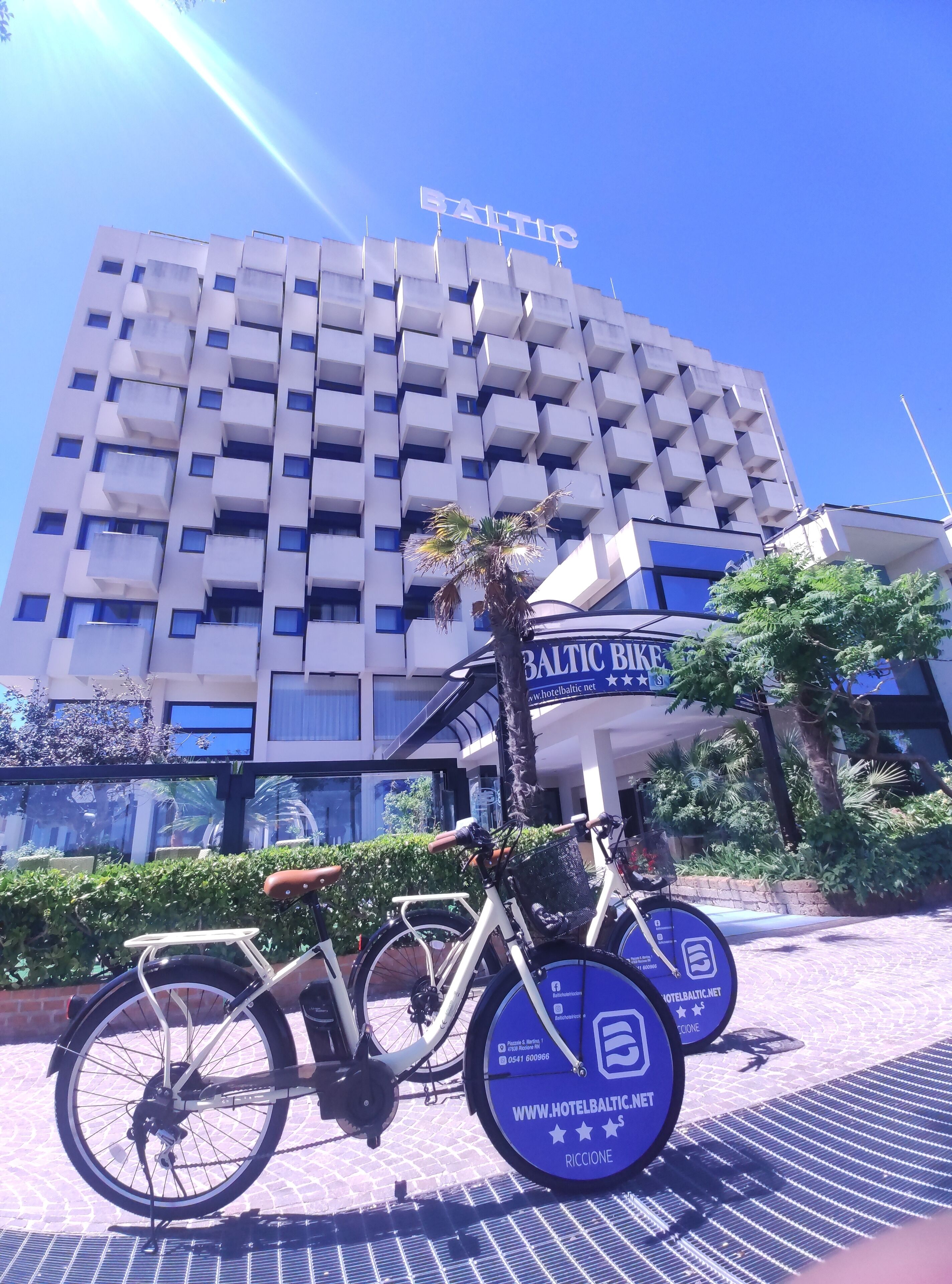 Un edificio moderno con un cartel que dice "BALTIC" y una estación de alquiler de bicicletas enfrente.
