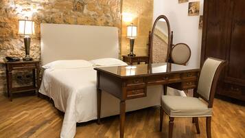 Un dormitorio con cama, cómoda de madera, espejo y una silla.