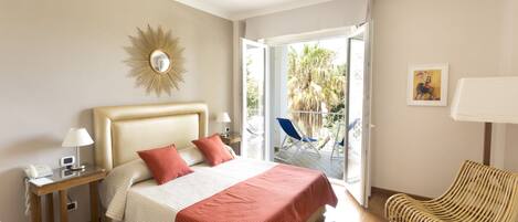 A hotel room with a bed, a nightstand, a chair, and a view of the outdoors.