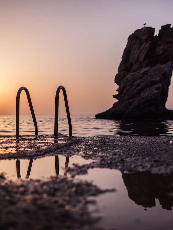 En la playa, sillas reclinables de playa, sombrillas, toallas de playa