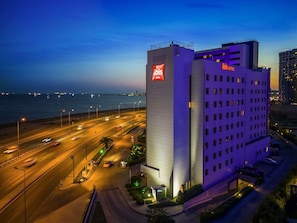 A hotel with a prominent ibis logo, a modern architectural design, and a view of the sea. - Ibis Istanbul Zeytinburnu (Istanbul)