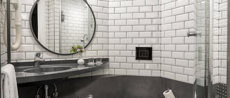 A modern bathroom with a black sink, white tiles, a round mirror, and a toilet.