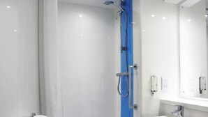 Ein modernes Badezimmer mit einer in Glas abgeschirmten Dusche, einem weißen Waschbecken und einem Handtuchhalter.