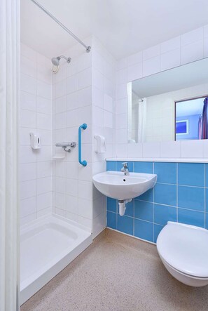 Une salle de bain avec une douche, un lavabo et des toilettes.