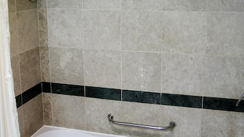 A bathroom with a bathtub, a towel rack, and a shower curtain.