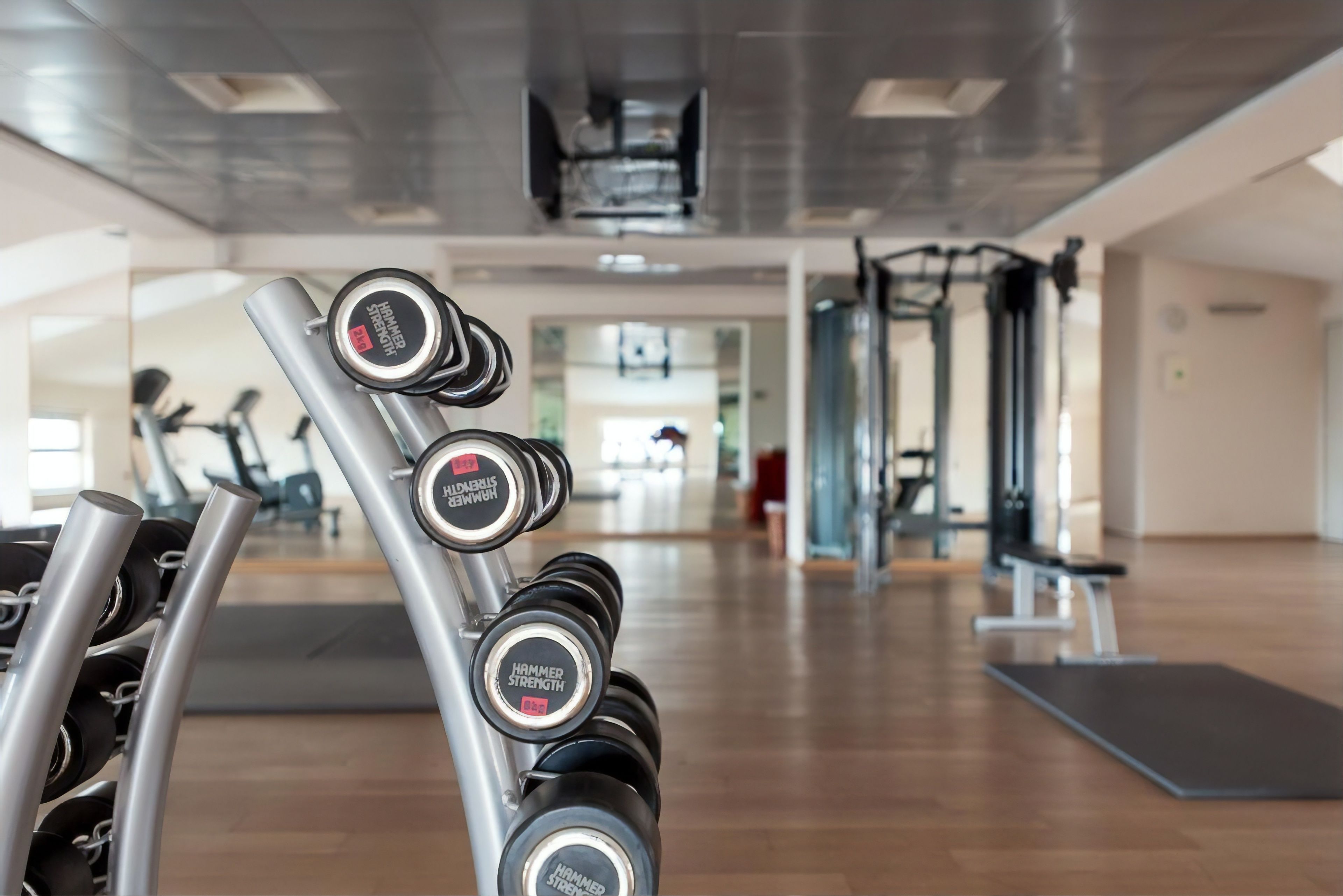 Un gimnasio con una barra de mancuernas que indica 'Hammer Strength'.