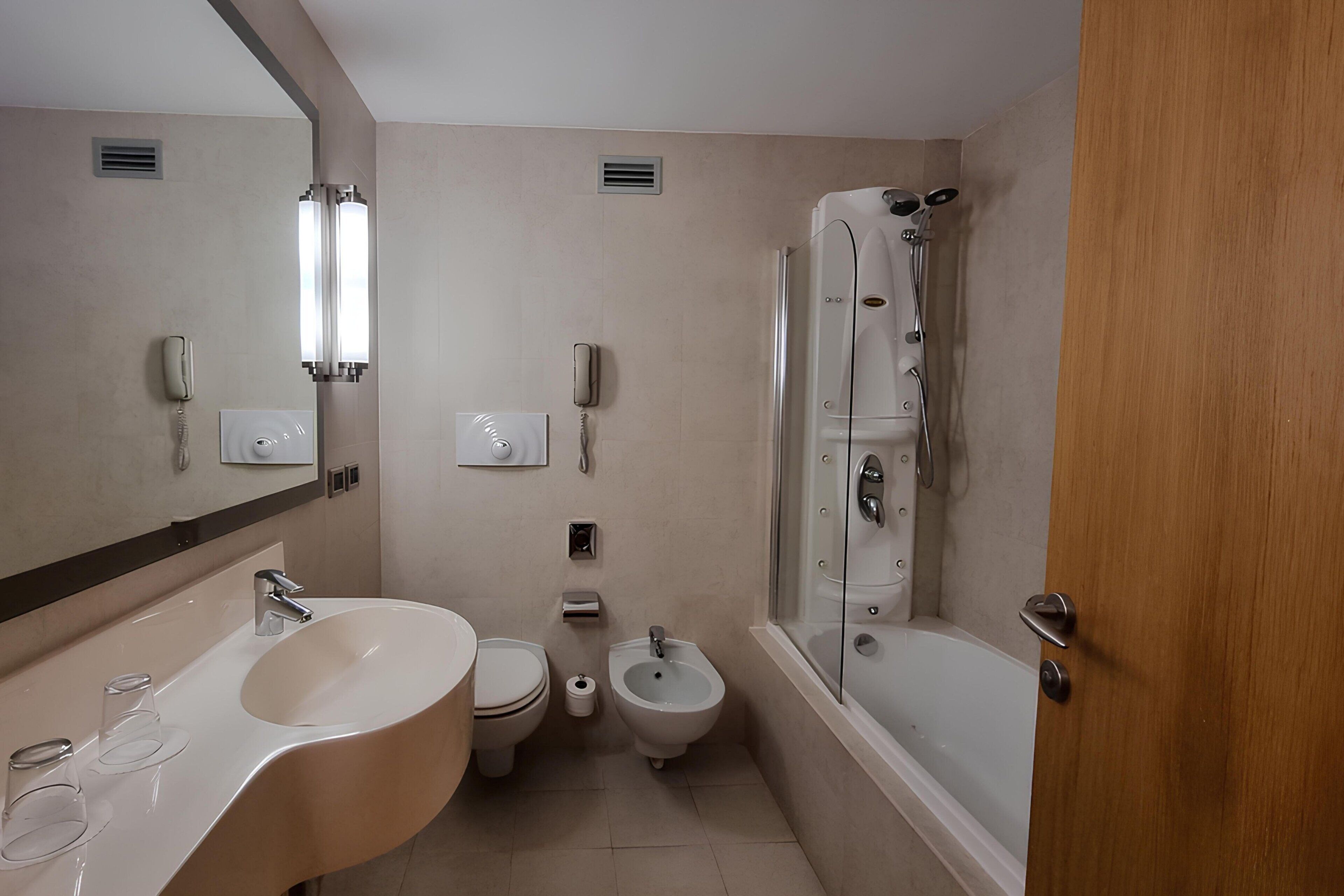 Une salle de bain moderne équipée d’un lavabo, de toilettes, d’un bidet et d’une douche à l’italienne.