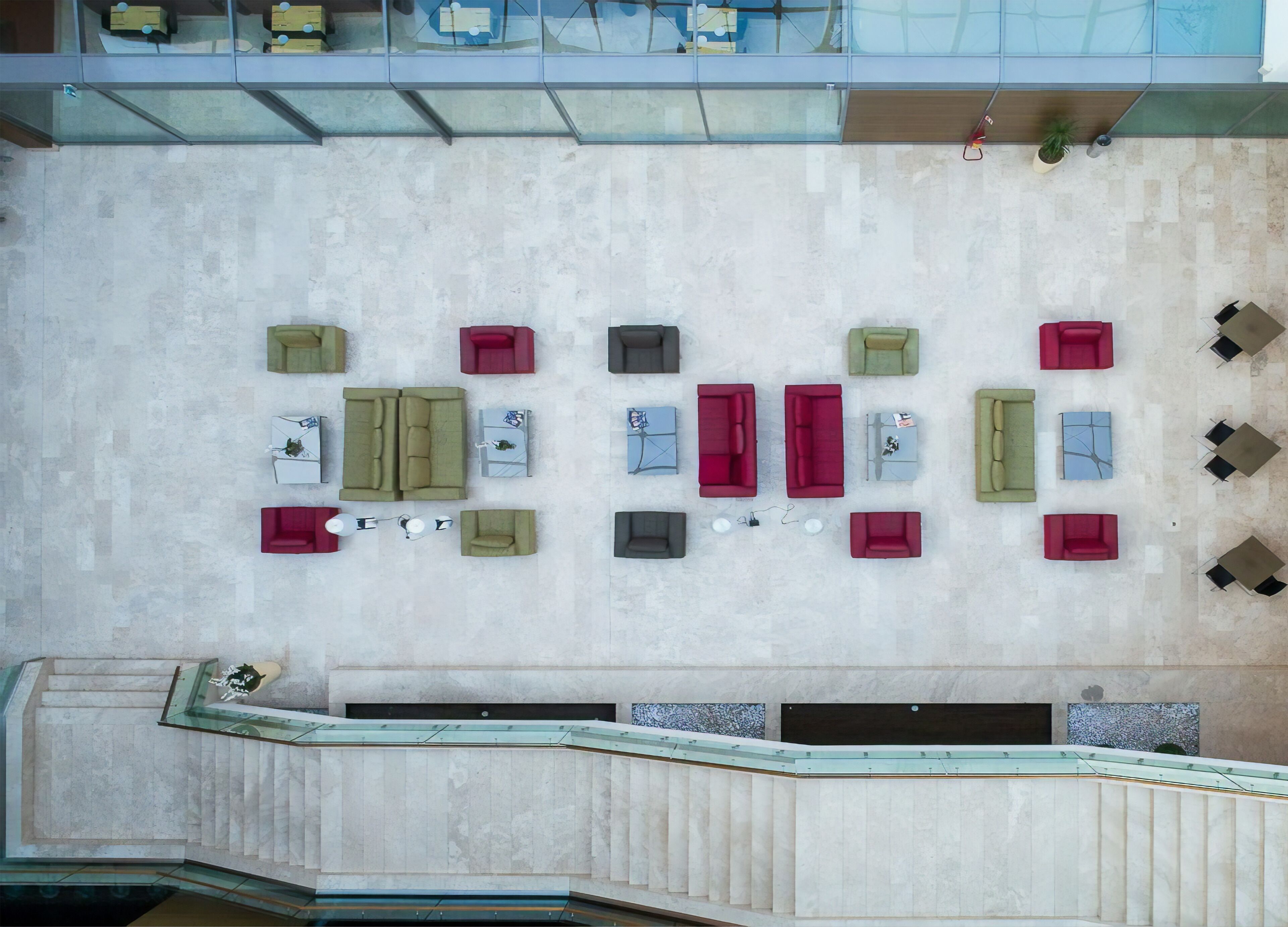 A top-down view of a hotel lobby with multiple seating areas, including sofas and tables, arranged in a spacious layout.