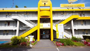 A hotel with a yellow facade, a central entrance, and a sign indicating it is a 'Premiere Classe' hotel. - Première Classe Epinay Sur Orge Savigny Sur Orge (Epinay-sur-Orge)