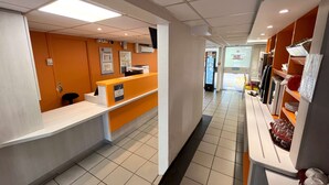 A hotel reception area with a counter, seating, and a vending machine. - Première Classe Epinay Sur Orge Savigny Sur Orge (Epinay-sur-Orge)
