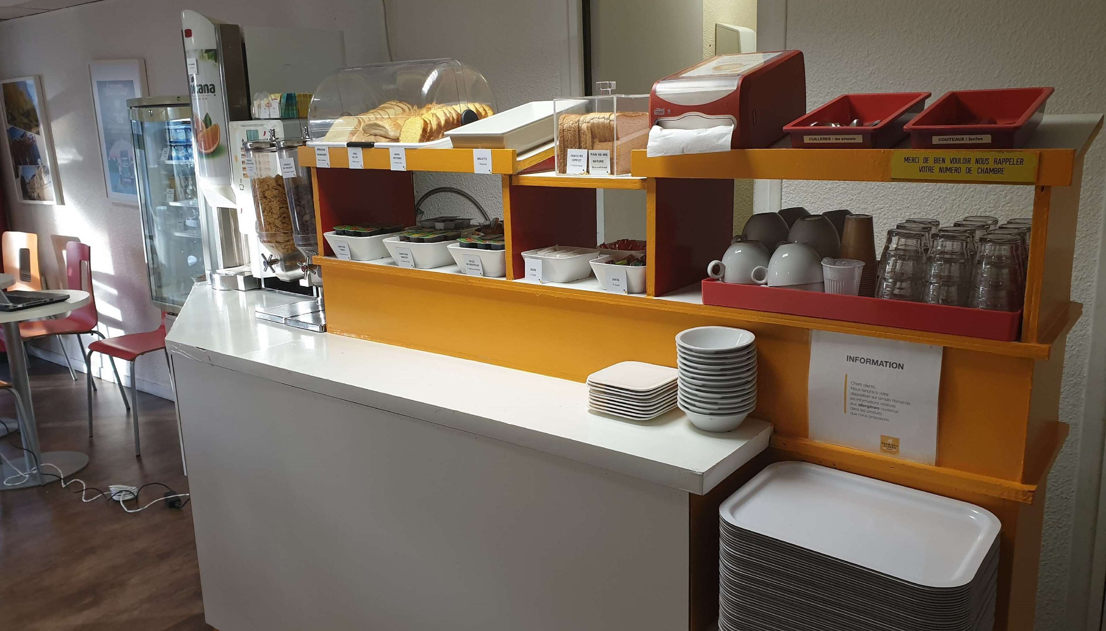 A breakfast bar with various food items and utensils.