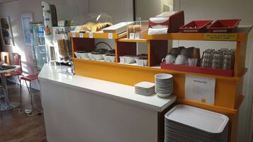 A breakfast bar with various food items and utensils.