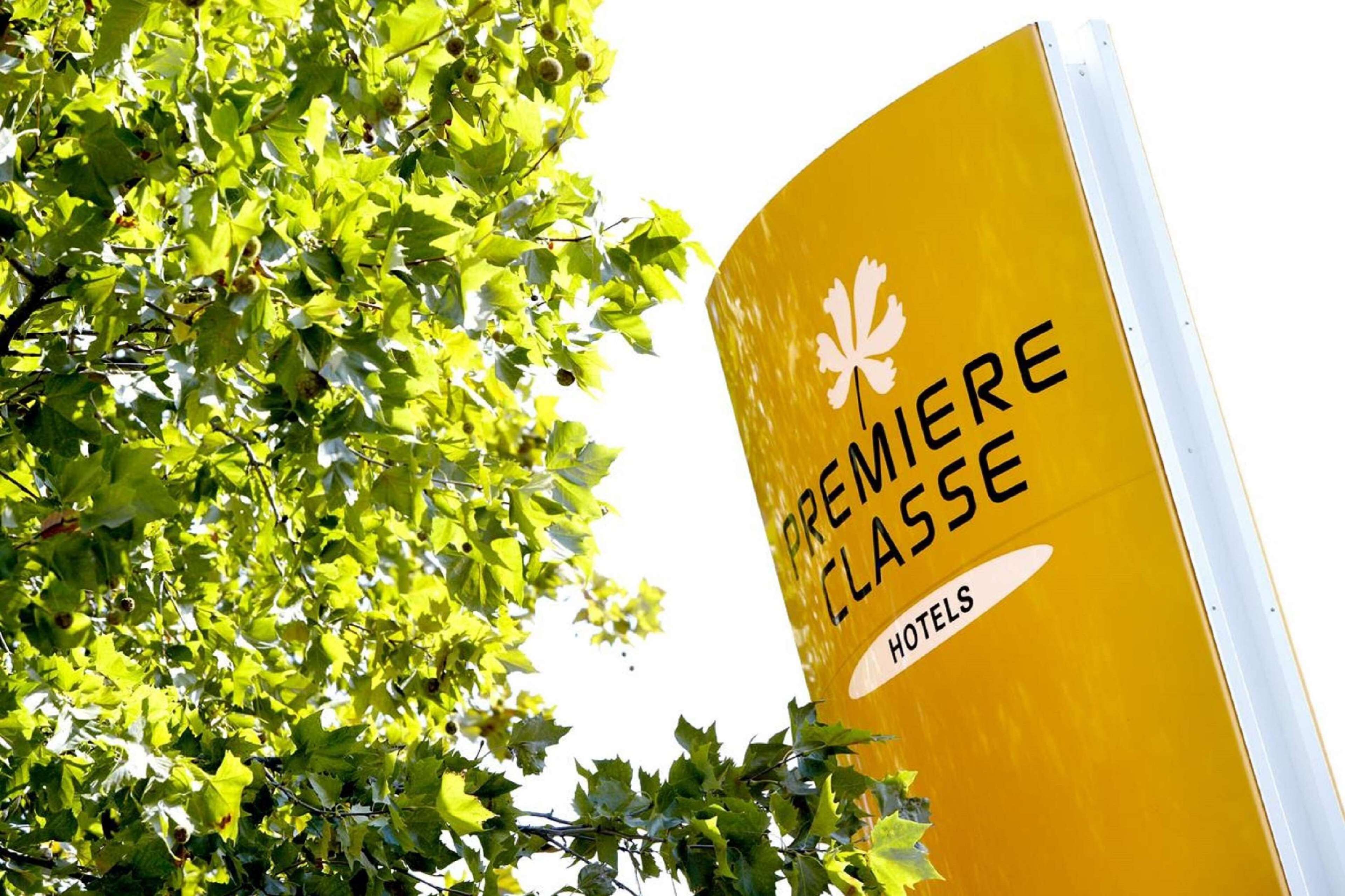 A yellow sign with the text "PREMIERE CLASSE HOTELS" and a maple leaf symbol.
