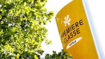 Un panneau jaune avec l’inscription « HÔTELS DE PREMIÈRE CLASSE » et un symbole représentant une feuille d’érable.