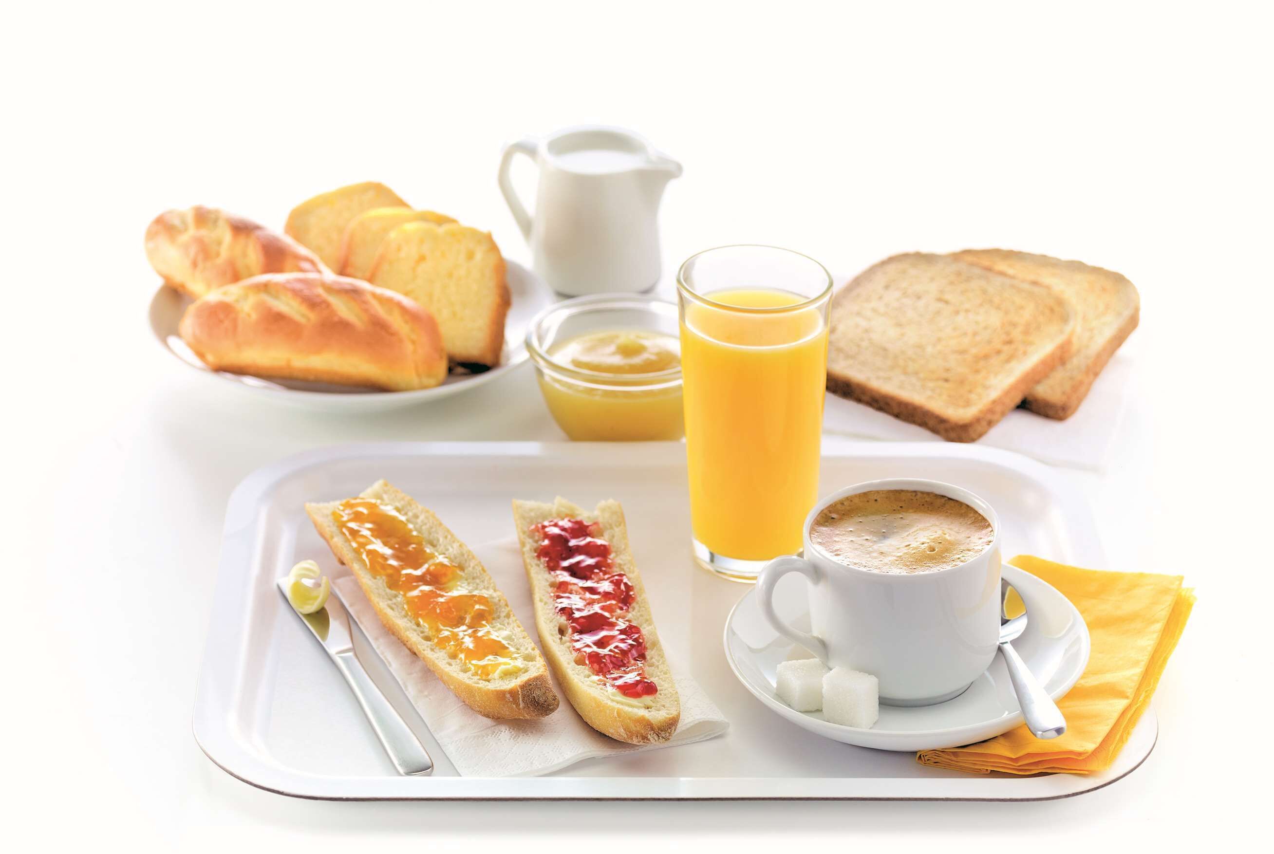 A tray with croissants, toast, jam, butter, a glass of orange juice, and a cup of coffee.