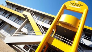 Un edificio amarillo y blanco con un letrero que dice 'Premiere Classe Hotels'.