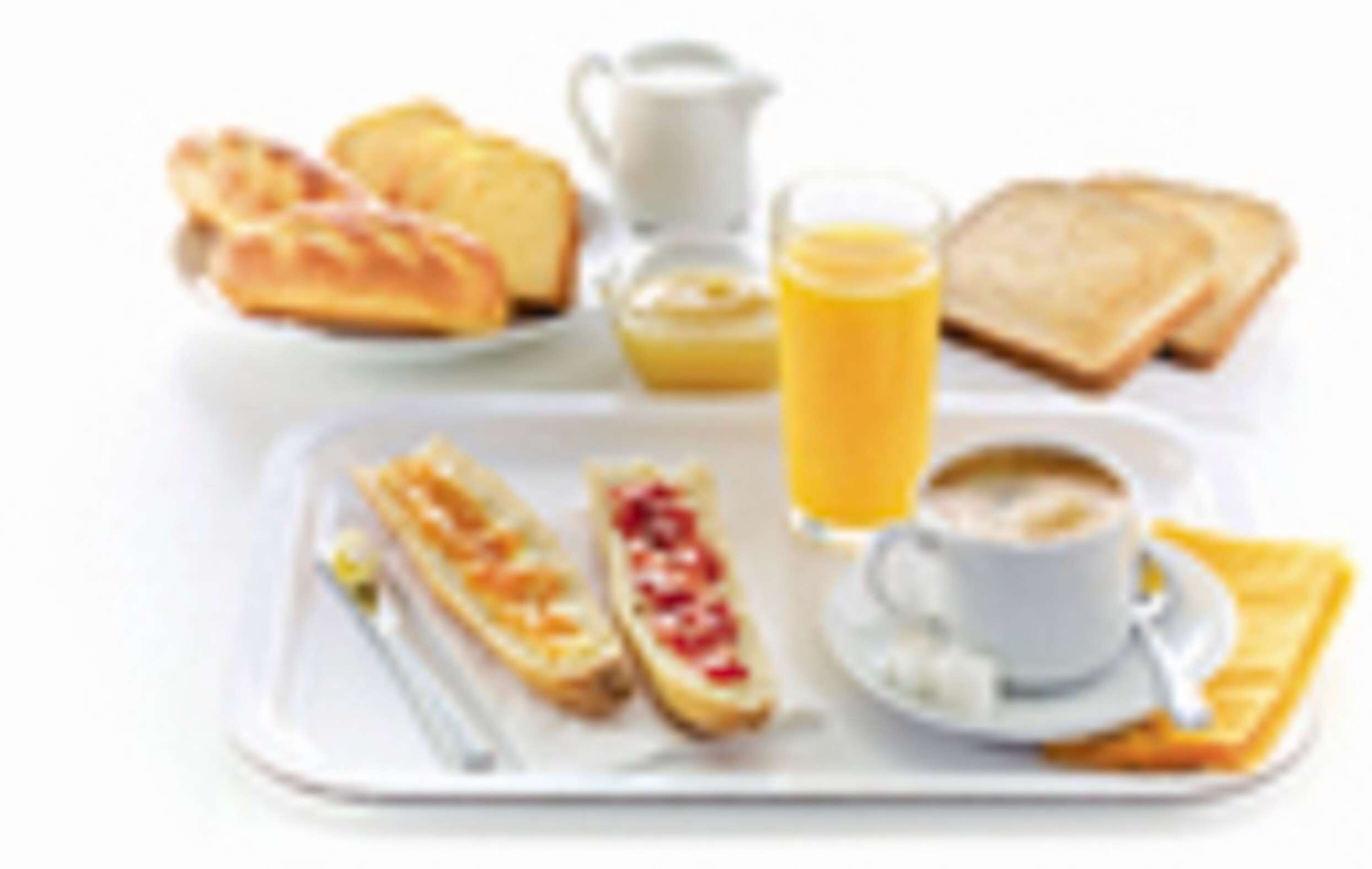 A breakfast tray with toast, pastries, a glass of orange juice, and a cup of coffee.