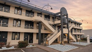 Ein Hotel mit mehreren Etagen, einer zentralen Treppe und einem Schild, das es als Hotel kennzeichnet.