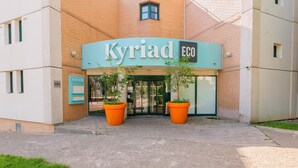 A building entrance with a sign reading 'Kyriad ECO' and a revolving door. - Kyriad ECO - Marne-la-Vallée Saint-Thibault-des-Vignes (Saint-Thibault-des-Vignes)