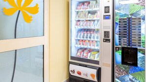 Ein Getränkeautomat mit digitalem Bildschirm und einer Auswahl an Snacks und Getränken.