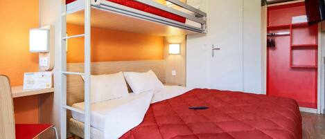 Una cama litera con un colchón rojo, un escritorio con una silla y un armario con puerta roja.