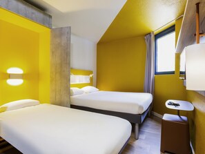 A hotel room with two beds, a small table, and a window. - ibis Budget Marne-la-Vallée Noisy-le-Grand (Noisy-le-Grand)
