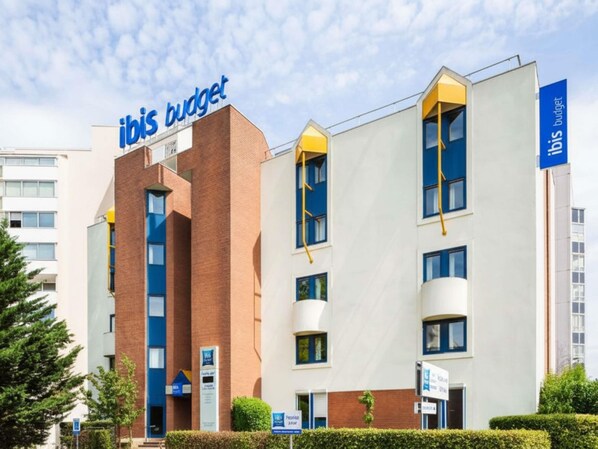 A modern hotel building with 'ibis budget' signage, a brick facade, and a white exterior. - ibis Budget Marne-la-Vallée Noisy-le-Grand (Noisy-le-Grand)
