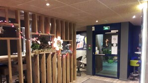 A reception area with a wooden partition, a reception desk, and a seating area with chairs.