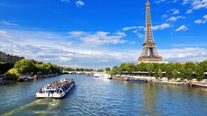 Un río con barcos y la Torre Eiffel al fondo.