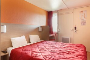 A hotel room with a bed, a desk, a chair, and a window with curtains. - Hotel Première Classe Chalons-en-Champagne (Saint-Martin-sur-le-Pre)
