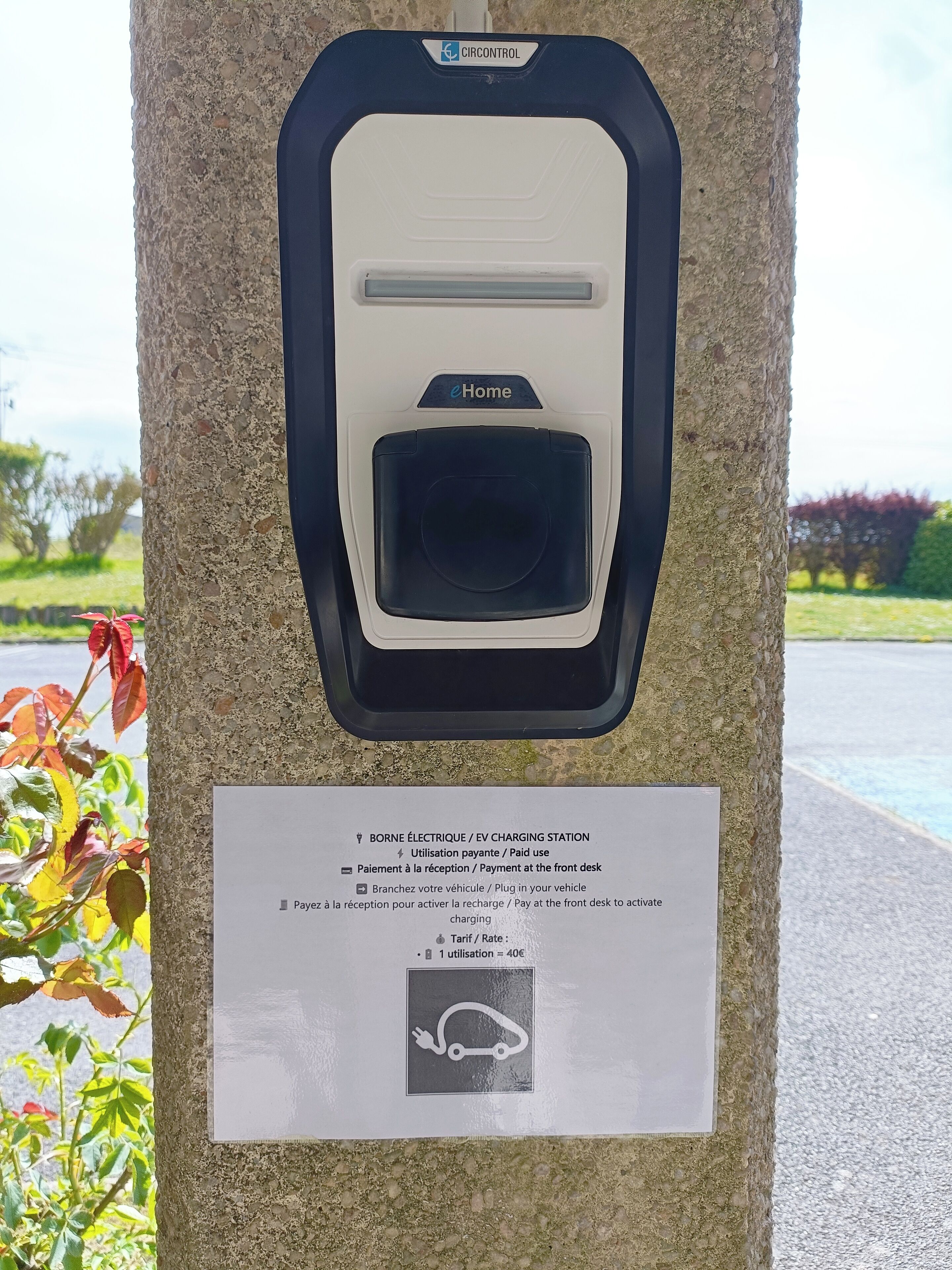 Een oplaadstation met de aanduiding 'eHome', voorzien van een plaquette met details over het gebruik en de betaalmogelijkheden.