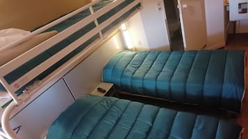 A bunk bed with a control panel and a small bedside table.
