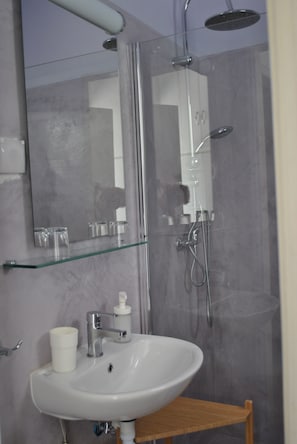 Habitación estándar con 1 cama doble o 2 individuales | Baño | Ducha, bidé y toallas