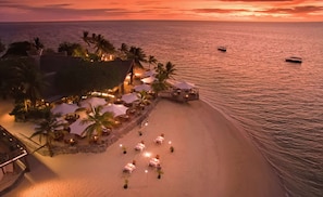 A beachfront resort with outdoor seating and umbrellas, a pool area, and a view of the ocean. - Castaway Island, Fiji (Castaway Island)