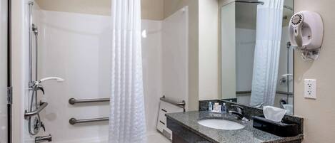 Une salle de bain moderne équipée d’une baignoire, d’une douche et d’un meuble-lavabo avec un évier et un miroir.