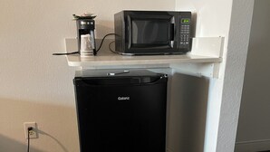 A compact kitchen area with a microwave and a black dishwasher.