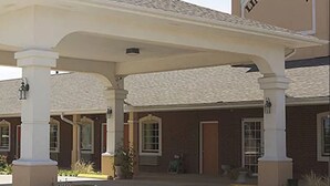 A building with a sign reading "Lindsay Inn" and a covered entrance area with columns.
